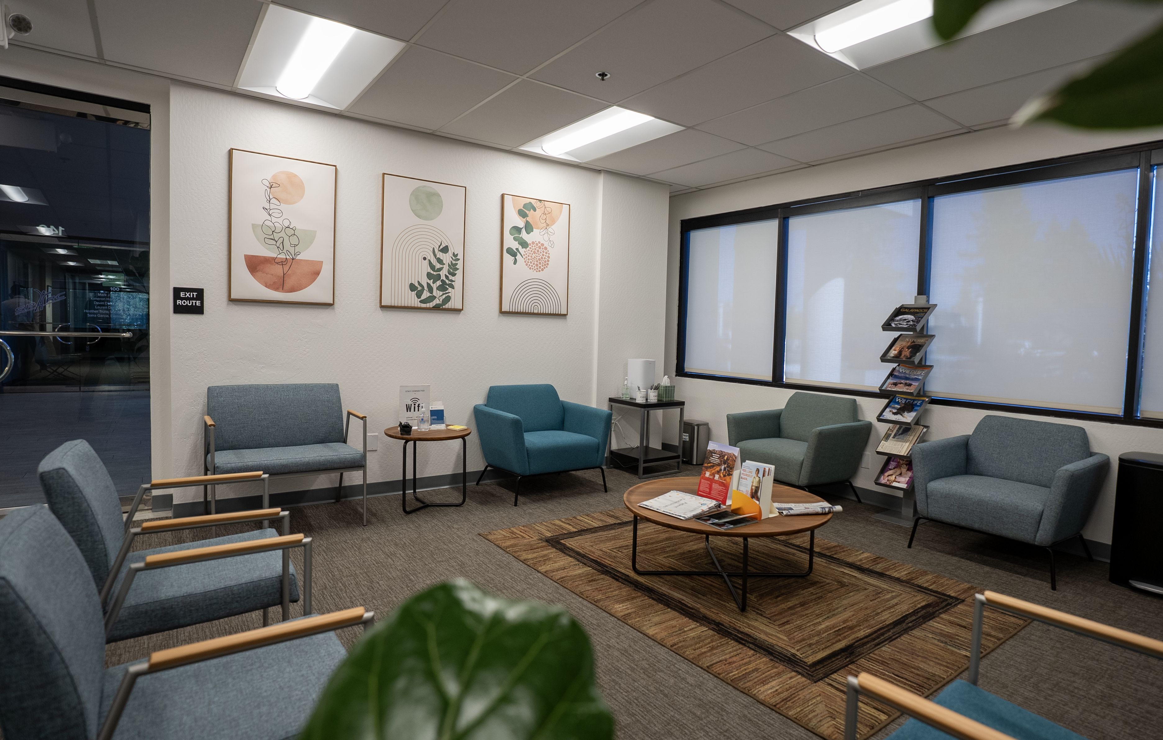 San Mateo waiting room with blue chairs, botanical prints, and a coffee table.