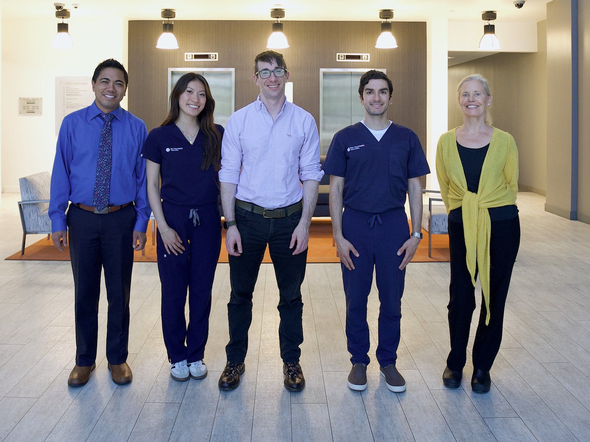 Five members of the Bay Psychiatric Associates team in the lobby of the San Mateo office building.